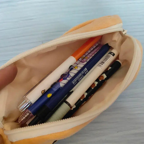 Open pencil bag showing assorted pens and markers inside a plush pencil case designed for kids.
