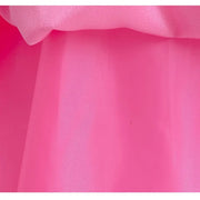 Close-up of the layered peach fabric of a children's dress, showcasing its vibrant pink color and smooth texture.